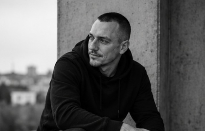 Tassilo Wolfin auf einer Dachterrasse, im Hintergrund die Stadt.